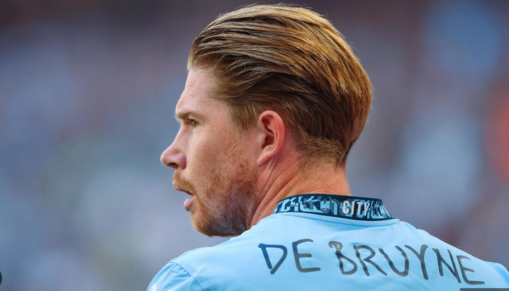 A Manchester City football player with "DE BRUYNE" on his jersey looks to the side during a match, capturing a possible farewell moment.