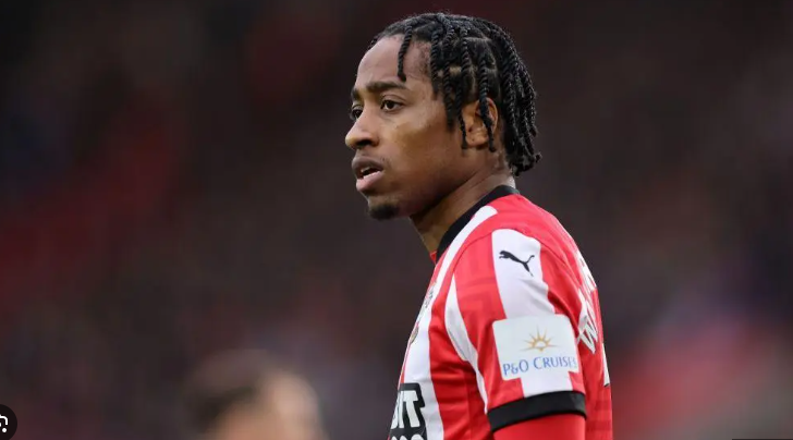 Football player in a red and white striped jersey with braids, looking to the side during a match—resembling England star Walker-Peters before his West Ham move.
