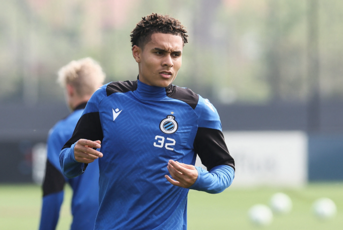 Norwegian Wonder-Wing Nusa, in a blue training kit with number 32, warms up on the field; others from AS Roma are blurred in the background.