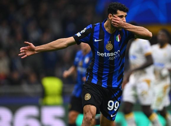 Inter Milan’s Iranian star celebrates a goal in blue and black stripes, arm outstretched and hand over mouth, shortly before his sudden exit.