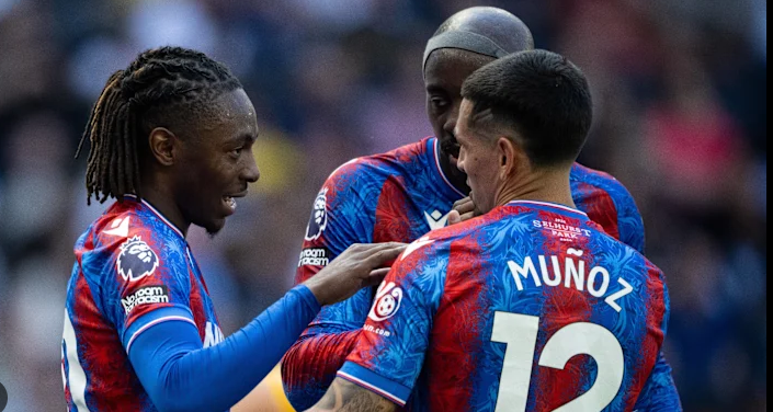 Three Crystal Palace football players in red and blue kits celebrate together during a match, showcasing the spirit that could drive them toward future Conference League opportunities amid discussions of Multi-Club Ownership.
