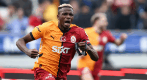 Galatasaray soccer player in a red and yellow jersey celebrates energetically during a match.