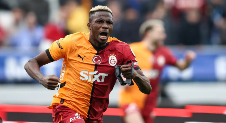 Galatasaray soccer player in a red and yellow jersey celebrates energetically during a match.