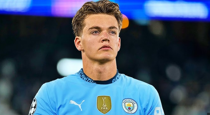 A Norwegian wonderkid in a Man City jersey stands on the field, looking focused and ready to make an impact.