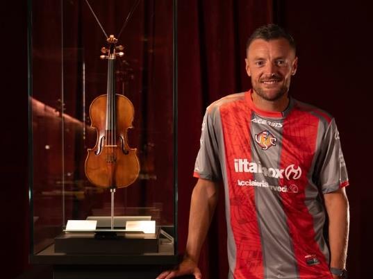 Jamie Vardy holding violin at Cremona violin museum marking Cremonese transfer